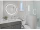 Modern bathroom with a sleek vanity, lighted round mirror, and glass-enclosed shower at 5910 Red Mangrove Ln, Bradenton, FL 34210