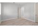A bright bedroom featuring wood-look floors, neutral walls, and a convenient doorway at 5910 Red Mangrove Ln, Bradenton, FL 34210