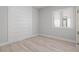 Empty bedroom features wood-look flooring, a paneled wall, and a window with white shutters at 5910 Red Mangrove Ln, Bradenton, FL 34210