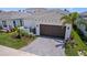 Charming home featuring an attached garage, a paved driveway, and lush front yard landscaping at 5910 Red Mangrove Ln, Bradenton, FL 34210