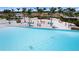 Palm trees and a sandy beach area border the edge of a Personal-made lagoon at 5910 Red Mangrove Ln, Bradenton, FL 34210