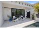A cozy outdoor patio features comfortable seating, tiled flooring, and a black-framed sliding glass door at 5910 Red Mangrove Ln, Bradenton, FL 34210