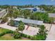 Charming home with a screen enclosed pool surrounded by lush tropical landscaping and a white gravel driveway at 5924 Gulf Of Mexico Dr, Longboat Key, FL 34228