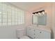 Modern bathroom with stone countertops and privacy window at 5924 Gulf Of Mexico Dr, Longboat Key, FL 34228