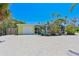 Rear view of house with screen enclosed pool and garage at 5924 Gulf Of Mexico Dr, Longboat Key, FL 34228