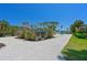Rear view of house with screen enclosed pool and garage at 5924 Gulf Of Mexico Dr, Longboat Key, FL 34228