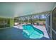 Inviting kidney-shaped pool inside screened enclosure with beautiful tropical landscaping at 5924 Gulf Of Mexico Dr, Longboat Key, FL 34228