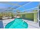 Clear kidney-shaped pool with screened lanai offering stunning views of the lush backyard at 5924 Gulf Of Mexico Dr, Longboat Key, FL 34228