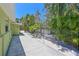 Property side yard featuring a pathway enclosed by a rod iron fence and tropical landscaping at 5924 Gulf Of Mexico Dr, Longboat Key, FL 34228