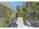 Charming walkway to the front door with tropical landscaping and a wooden gate at 5924 Gulf Of Mexico Dr, Longboat Key, FL 34228