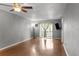 A bright living room with wood floors, a ceiling fan, and sliding glass doors to a balcony at 5964 7Th W Ave # 5964, Bradenton, FL 34209