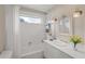 Well-lit bathroom with a tub-shower combo, white vanity, decorative mirror and sconce lighting at 6664 Deering Cir, Sarasota, FL 34240