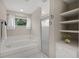 Bright bathroom featuring a soaking tub, glass-enclosed shower, and convenient built-in shelving at 6664 Deering Cir, Sarasota, FL 34240