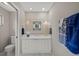 Bright bathroom with a white vanity, decorative mirror, sconce lighting, and tiled flooring at 6664 Deering Cir, Sarasota, FL 34240