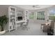Cozy home office with built-in bookshelves, a comfortable chair, and ample natural light at 6664 Deering Cir, Sarasota, FL 34240