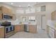 Well-lit kitchen featuring stainless steel appliances, light wood cabinetry, and tile flooring at 6664 Deering Cir, Sarasota, FL 34240
