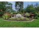 Community sign with beautiful landscaping, showcasing the entrance to the Deerfield neighborhood at 6664 Deering Cir, Sarasota, FL 34240