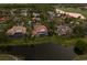 Aerial view of property showing the backyard pool, mature trees, and surrounding landscaping near a lake at 6919 Westchester Cir, Lakewood Ranch, FL 34202