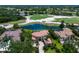 A stunning aerial view showcasing the home's tile roof, pool, lush landscaping, and the neighboring golf course at 6919 Westchester Cir, Lakewood Ranch, FL 34202