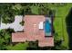 Overhead shot of a property, highlighting the tile roof, pool, and landscaping amidst a backdrop of greenery and a pond at 6919 Westchester Cir, Lakewood Ranch, FL 34202