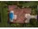Overhead view of a backyard with a swimming pool and spa surrounded by manicured landscaping and trees at 6919 Westchester Cir, Lakewood Ranch, FL 34202
