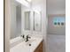 Bathroom with vanity, sink, mirror, and view to bedroom and window with shutters at 6919 Westchester Cir, Lakewood Ranch, FL 34202