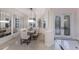 Bright dining room featuring a modern table setting, white chairs, large mirrors, and decorative doors at 6919 Westchester Cir, Lakewood Ranch, FL 34202