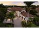 Aerial view of a stately home with a brick driveway, mature palm trees, and manicured greenery at 6919 Westchester Cir, Lakewood Ranch, FL 34202
