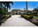 Inviting home boasting lush landscaping, a brick paver driveway, and a barrel tile roof for a timeless aesthetic at 6919 Westchester Cir, Lakewood Ranch, FL 34202