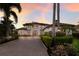 Stately two-story home with lush landscaping and paver driveway at sunset at 6919 Westchester Cir, Lakewood Ranch, FL 34202