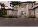 Elegant home entrance featuring a brick driveway, manicured landscaping and a grand portico with columns at 6919 Westchester Cir, Lakewood Ranch, FL 34202