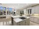 A luxurious white kitchen features stainless steel appliances, granite countertops, and a wine rack in the island at 6919 Westchester Cir, Lakewood Ranch, FL 34202