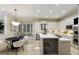 A well-lit kitchen with a breakfast nook, modern appliances, a wine rack, and a marble-topped island at 6919 Westchester Cir, Lakewood Ranch, FL 34202