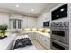 Modern kitchen with stainless steel appliances, white cabinetry, granite counters, and tile backsplash at 6919 Westchester Cir, Lakewood Ranch, FL 34202