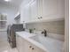 Laundry room with modern appliances, white cabinets, and a countertop with sink at 6919 Westchester Cir, Lakewood Ranch, FL 34202