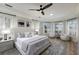 Bright main bedroom with bay window, plantation shutters, decorative rug, ceiling fan, and designer furnishings at 6919 Westchester Cir, Lakewood Ranch, FL 34202
