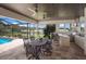 Outdoor covered patio featuring a grill, bar, and dining area with views of the pool and golf course at 6919 Westchester Cir, Lakewood Ranch, FL 34202