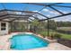 Screened-in pool area featuring a pool with fountain features, spa and lush landscaping at 6919 Westchester Cir, Lakewood Ranch, FL 34202