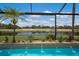 Relaxing pool area with water features and views of the golf course beyond the screened enclosure at 6919 Westchester Cir, Lakewood Ranch, FL 34202