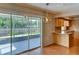 Bright kitchenette with sliding glass doors to the patio, wooden cabinetry, and hardwood floors at 7719 9Th Avenue Nw Dr, Bradenton, FL 34209