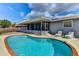 A refreshing kidney-shaped pool surrounded by a screened-in lanai and lush landscaping, perfect for outdoor relaxation at 7719 9Th Avenue Nw Dr, Bradenton, FL 34209