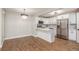 Dining area with chandelier and view of updated kitchen featuring modern stainless steel appliances at 1151 Pine Ridge W Cir # H1, Tarpon Springs, FL 34688