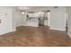 Open-concept living room with hardwood floors, modern chandelier, and access to the kitchen at 1151 Pine Ridge W Cir # H1, Tarpon Springs, FL 34688