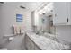 Bathroom featuring a marble vanity and an oversized mirror with modern lighting fixtures at 1400 1St W Ave # 203, Bradenton, FL 34205