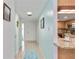 Hallway with light blue walls leading to kitchen, doors, and storage at 1400 1St W Ave # 203, Bradenton, FL 34205