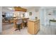 Open kitchen featuring a breakfast bar with granite countertops, wood cabinets and a lovely view into the living room at 1400 1St W Ave # 203, Bradenton, FL 34205