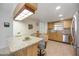 Bright kitchen with granite countertops, wood cabinetry, and stainless steel appliances at 1400 1St W Ave # 203, Bradenton, FL 34205