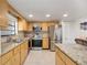 Well-equipped kitchen with stainless steel appliances, wood cabinetry, and tile flooring at 1400 1St W Ave # 203, Bradenton, FL 34205