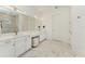 Modern bathroom with double vanity, marble floors, and a large mirror with stylish lighting at 15605 Derna Ter, Bradenton, FL 34211