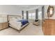 Inviting bedroom with bay windows, shutters, soft carpet, and comfortable armchair at 15605 Derna Ter, Bradenton, FL 34211